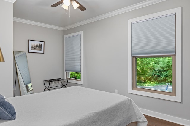 bedroom featuring crown molding, wood finished floors, baseboards, and a ceiling fan