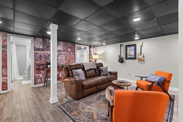 living room with baseboards, wood finished floors, a paneled ceiling, and recessed lighting