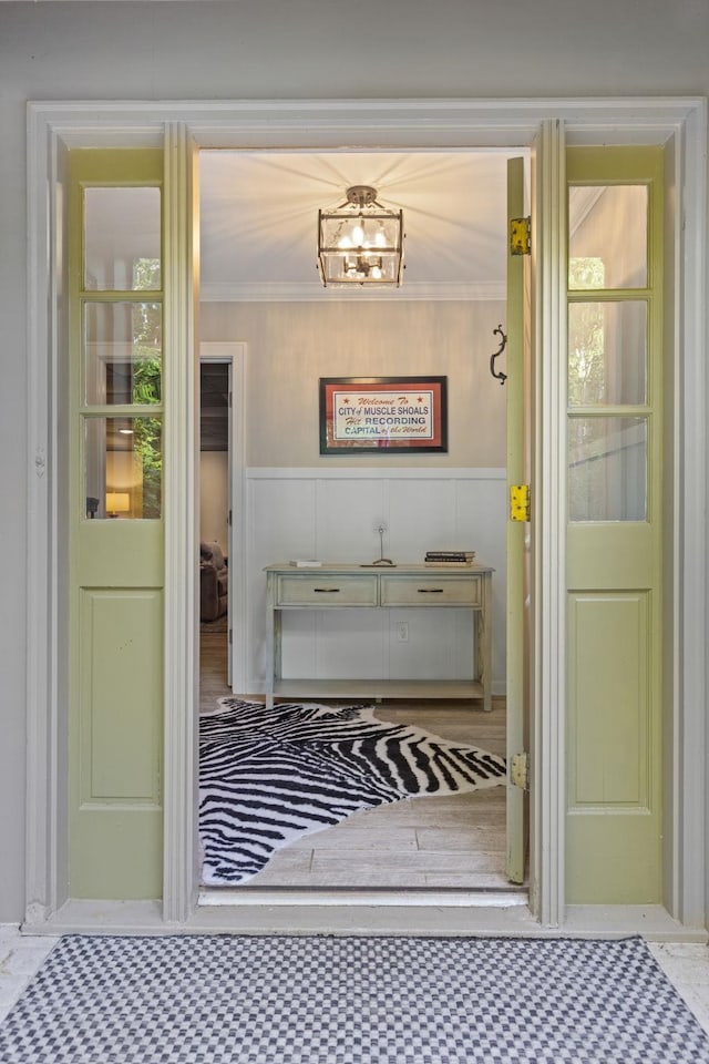 mudroom featuring wainscoting and crown molding
