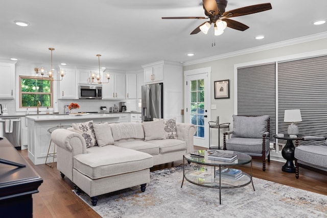 living area with a chandelier, wood finished floors, ornamental molding, ceiling fan, and recessed lighting