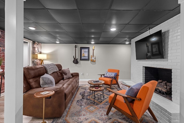 living area with a fireplace, baseboards, recessed lighting, and a paneled ceiling