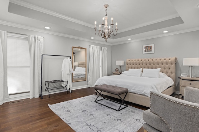 bedroom with a tray ceiling, a chandelier, dark wood-style floors, recessed lighting, and crown molding