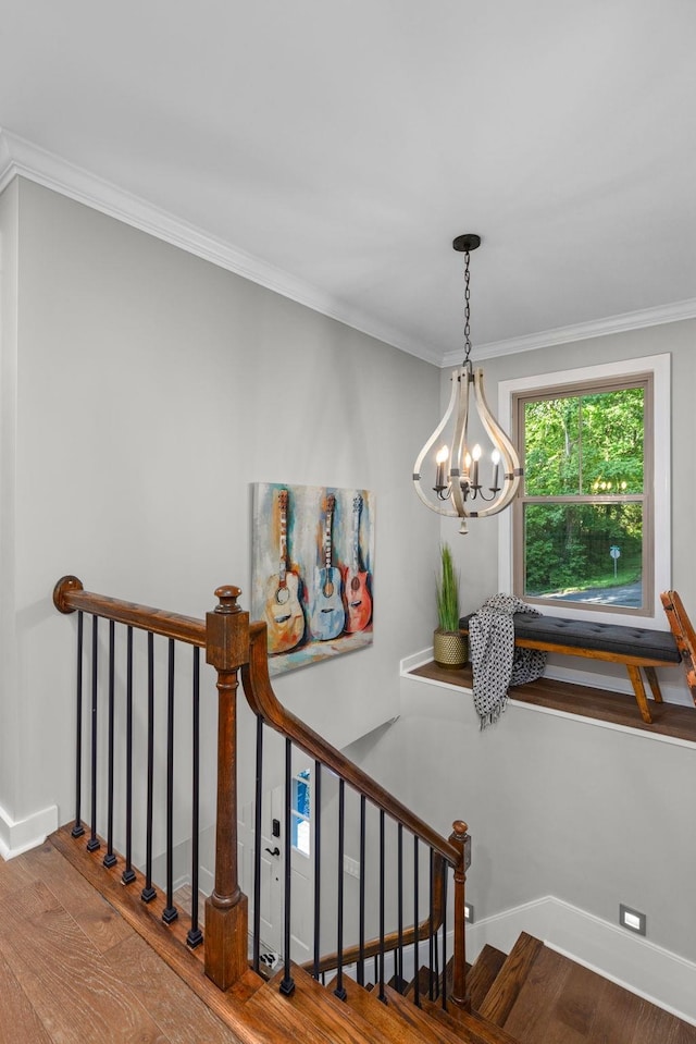 staircase featuring wood finished floors, a chandelier, ornamental molding, and baseboards