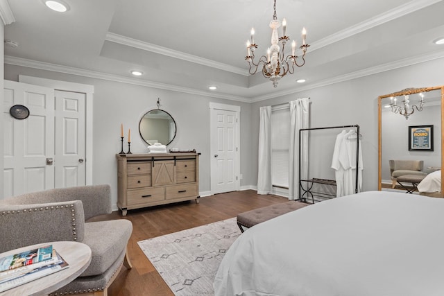bedroom with a chandelier, wood finished floors, a raised ceiling, recessed lighting, and ornamental molding