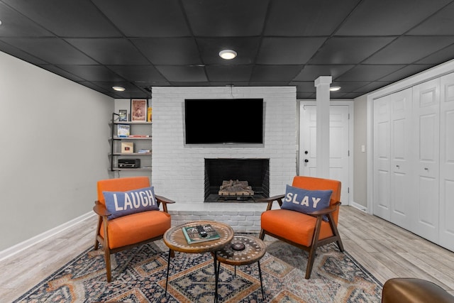 living area featuring wood finished floors, baseboards, and a fireplace