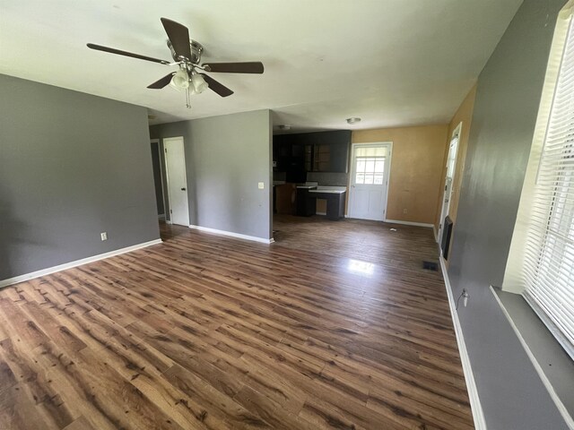  - unfurnished living room with baseboards, dark wood-style flooring, and ceiling fan