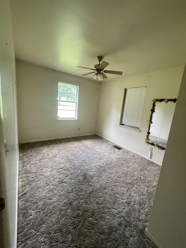 - empty room featuring carpet flooring, ceiling fan, and baseboards