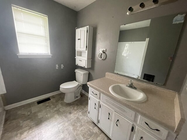  - bathroom featuring baseboards, toilet, and vanity