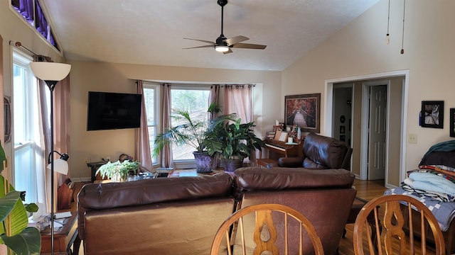 living room with light wood-type flooring, vaulted ceiling, ceiling fan, and a healthy amount of sunlight