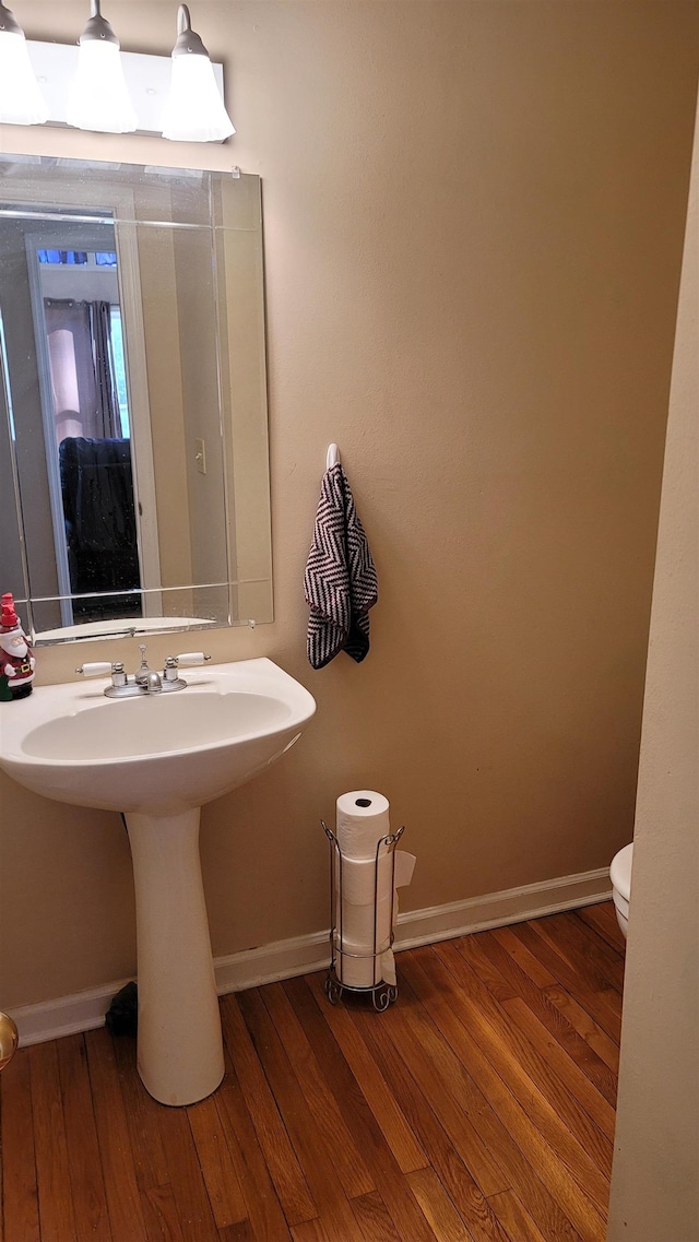 bathroom with hardwood / wood-style floors, toilet, and sink