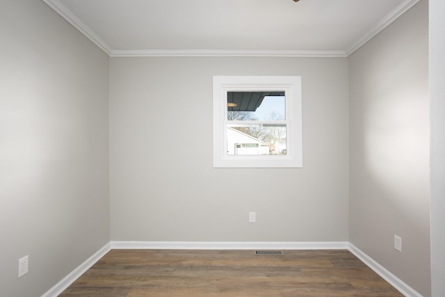 empty room featuring ornamental molding and dark hardwood / wood-style floors