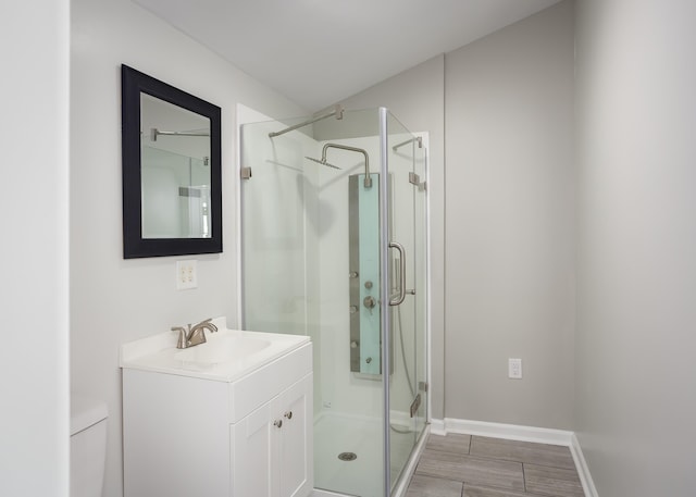 bathroom featuring an enclosed shower, vanity, and toilet