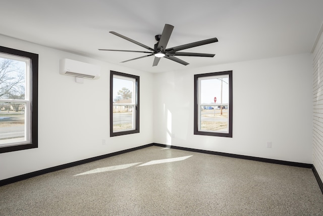 spare room with a wealth of natural light, an AC wall unit, and ceiling fan