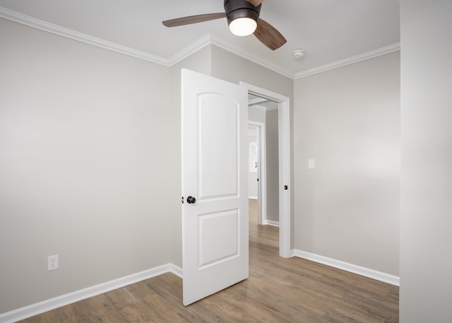 spare room with wood-type flooring, ornamental molding, and ceiling fan