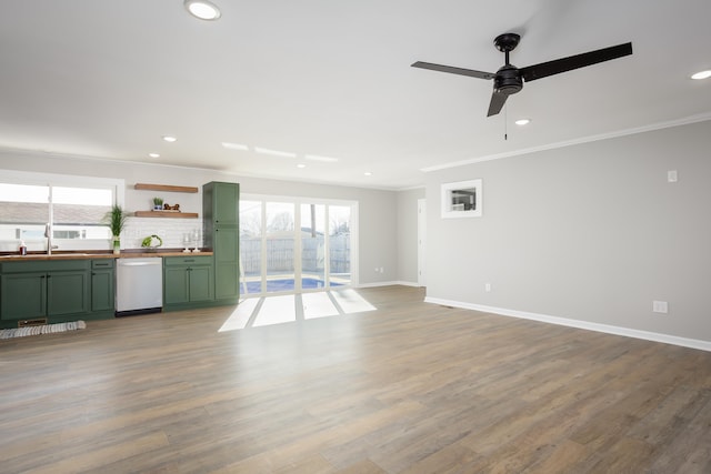 unfurnished living room with ceiling fan, crown molding, hardwood / wood-style floors, and sink