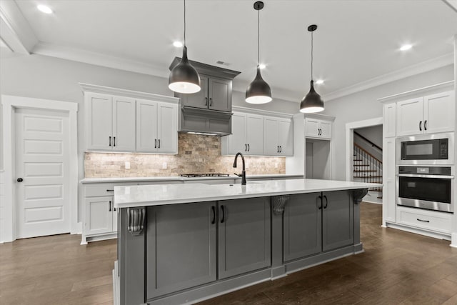 kitchen with a large island, oven, white cabinetry, and built in microwave