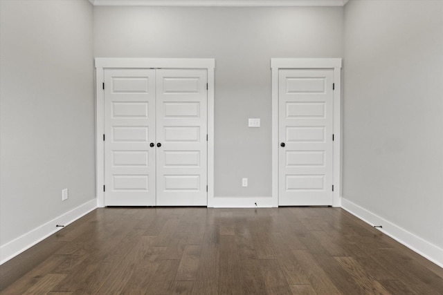 unfurnished bedroom with dark wood-type flooring