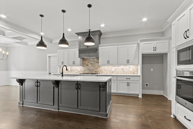 kitchen featuring a large island with sink, white cabinetry, pendant lighting, and appliances with stainless steel finishes