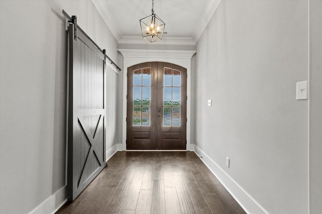 entryway featuring an inviting chandelier, french doors, a water view, a barn door, and ornamental molding