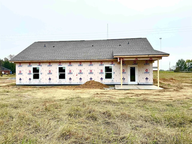 rear view of property featuring a lawn