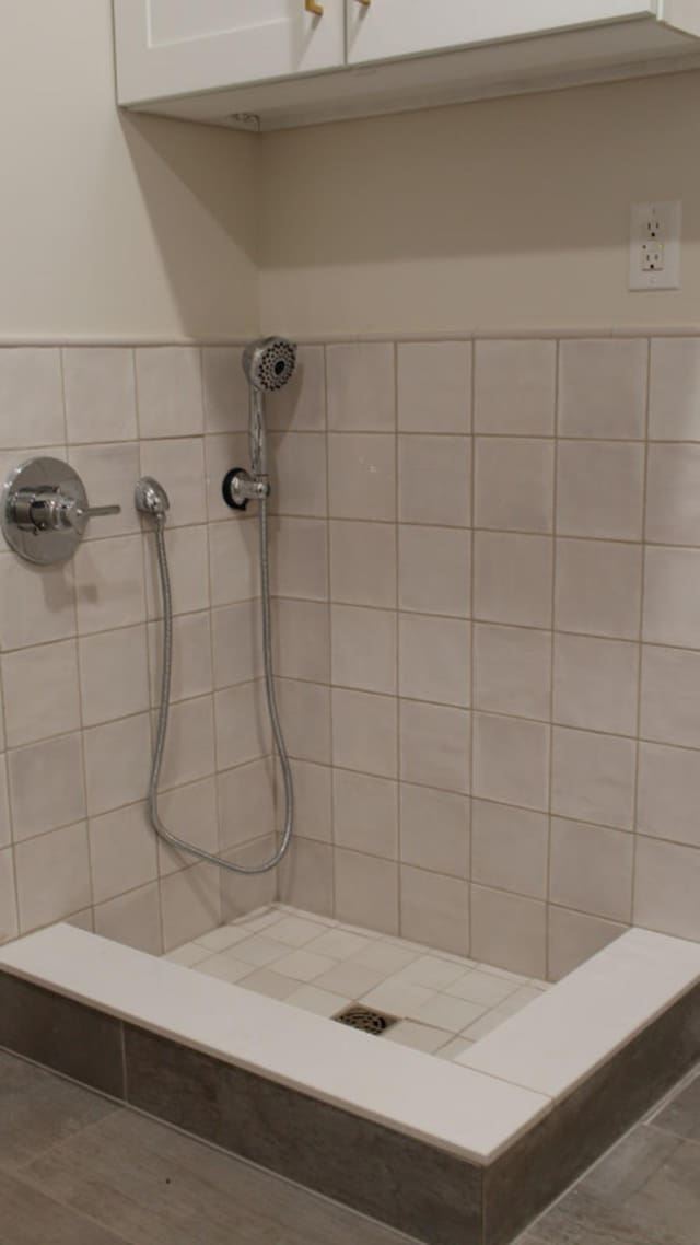 bathroom featuring tile patterned flooring and tiled shower