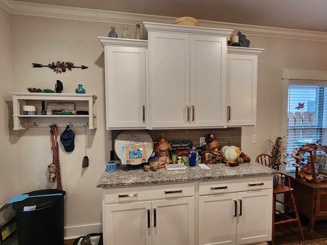 kitchen featuring light stone counters and white cabinetry