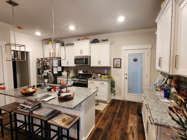 kitchen with white cabinets, decorative light fixtures, and stainless steel appliances