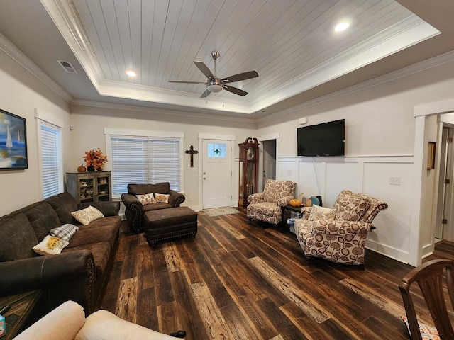 living room featuring a tray ceiling, ceiling fan, ornamental molding, and dark hardwood / wood-style floors