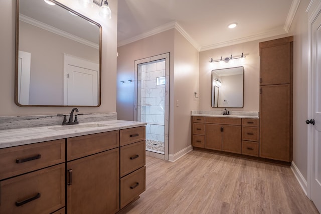 bathroom featuring vanity, crown molding, tiled shower, and hardwood / wood-style floors