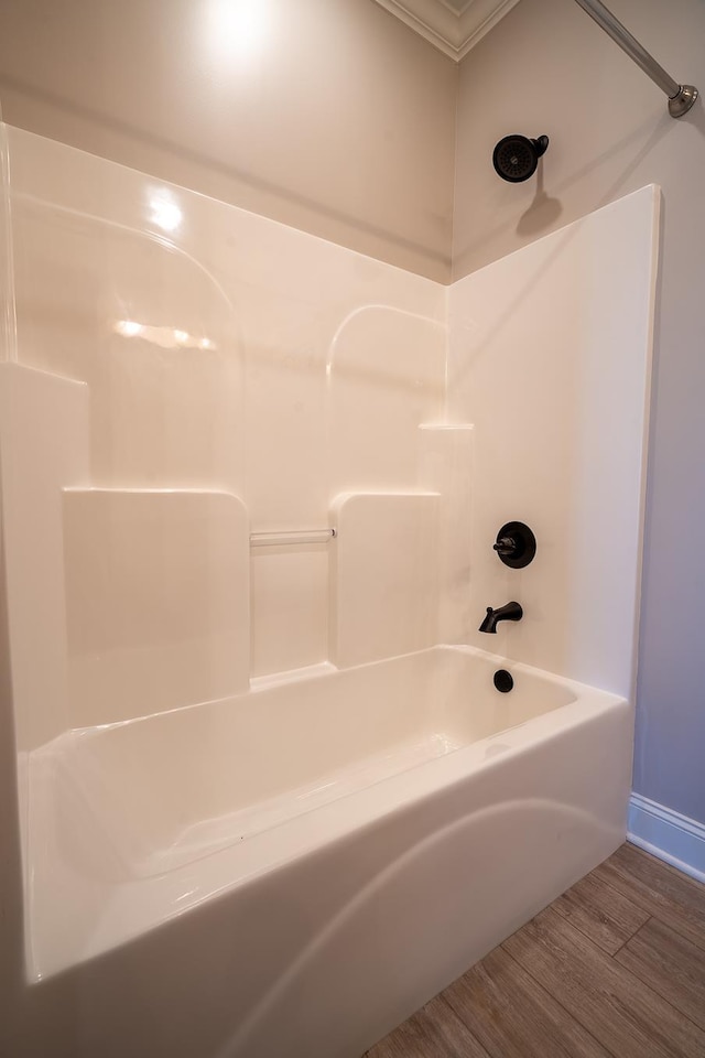 bathroom with hardwood / wood-style flooring and shower / tub combination