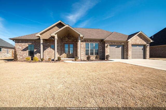 craftsman house with a garage and a front lawn