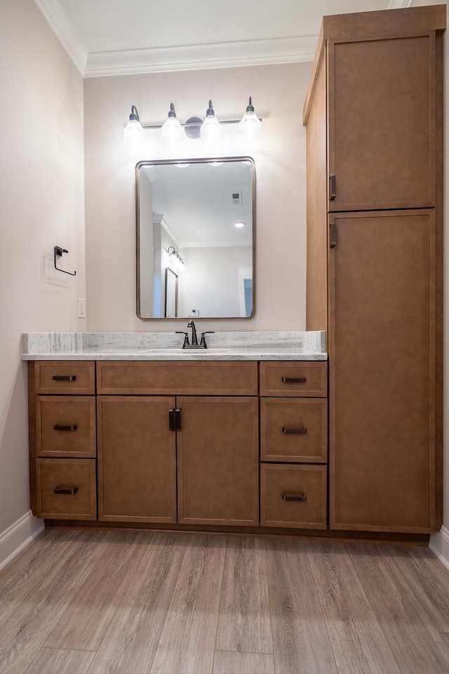 bathroom with hardwood / wood-style floors, vanity, and ornamental molding