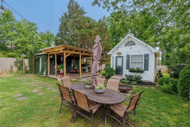  - view of yard featuring an outbuilding, outdoor dining area, and a wooden deck