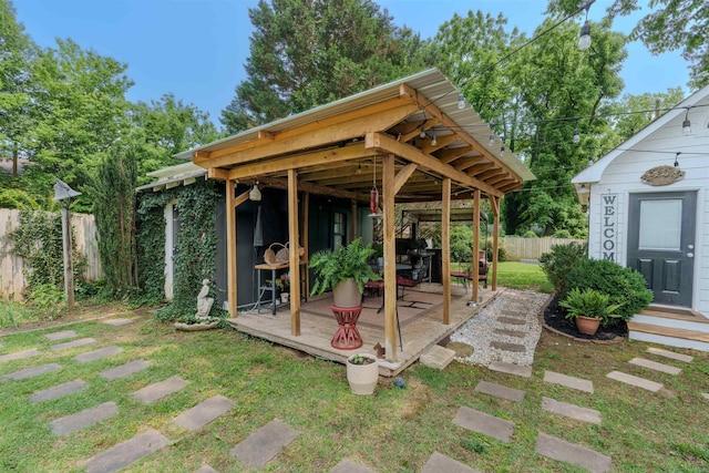  - view of patio / terrace with a deck and an outbuilding