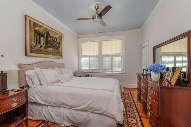  - bedroom featuring wood finished floors, crown molding, and a ceiling fan