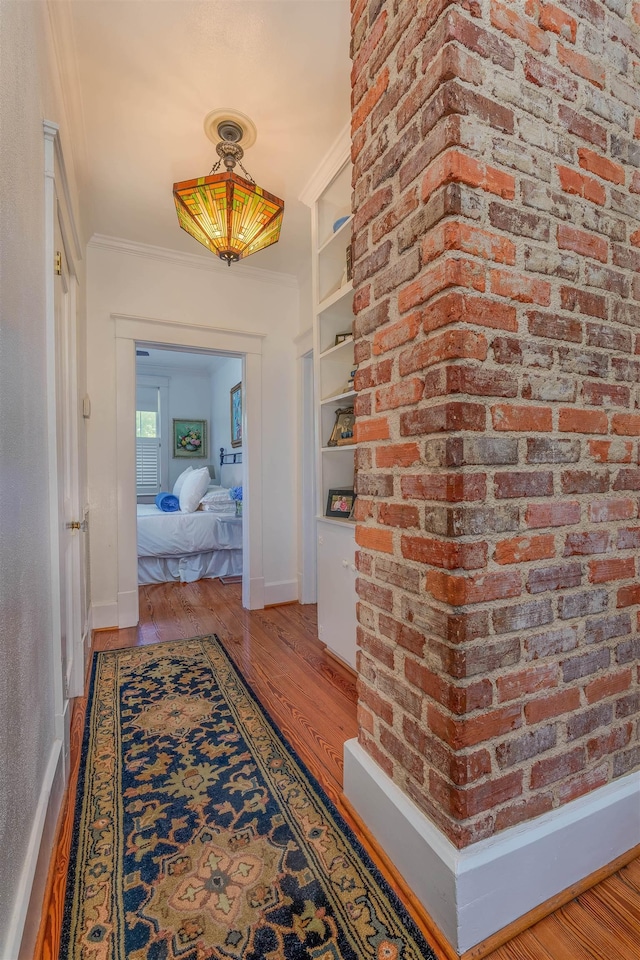  - corridor featuring crown molding, wood finished floors, and baseboards