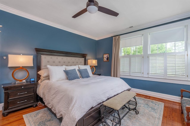  - bedroom featuring crown molding, baseboards, wood finished floors, and ceiling fan