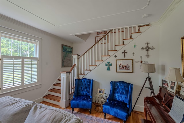  - stairs featuring wood finished floors, ornamental molding, and baseboards