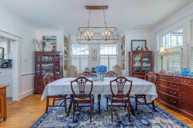  - dining area with a chandelier, healthy amount of natural light, light wood-type flooring, and ornamental molding