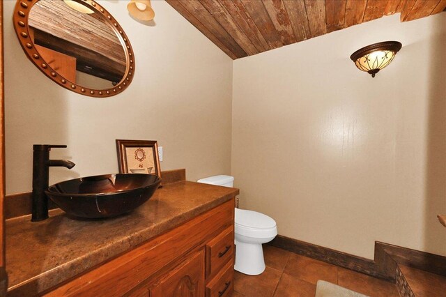  - bathroom with wooden ceiling, vanity, toilet, vaulted ceiling, and tile patterned flooring