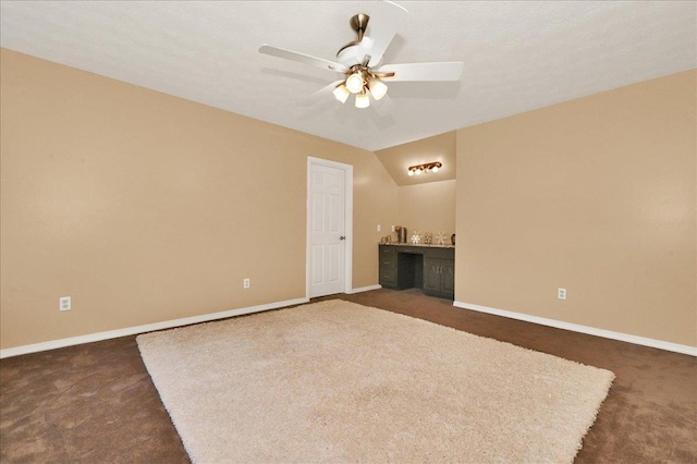  - spare room with dark carpet, ceiling fan, and baseboards