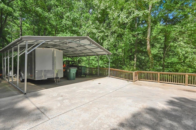  - view of parking / parking lot with a detached carport and concrete driveway