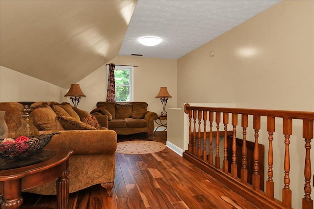  - living room featuring dark wood-style floors, vaulted ceiling, baseboards, and a textured ceiling
