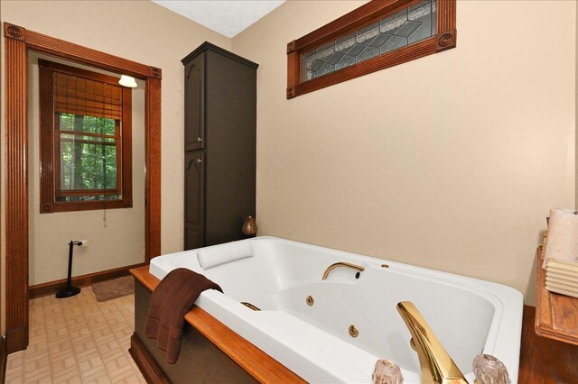  - bathroom featuring a jetted tub and baseboards