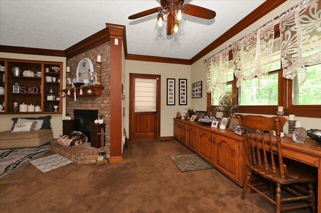  - office space featuring a ceiling fan, carpet flooring, crown molding, and a brick fireplace