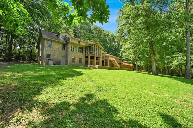  - rear view of house with a yard, a sunroom, a deck, stairway, and central AC