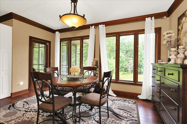  - dining area with healthy amount of natural light, baseboards, dark wood-style flooring, and ornamental molding