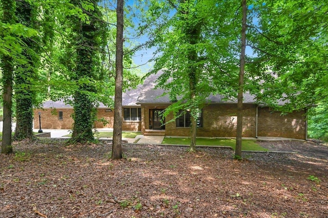  - rear view of house featuring a shingled roof and brick siding