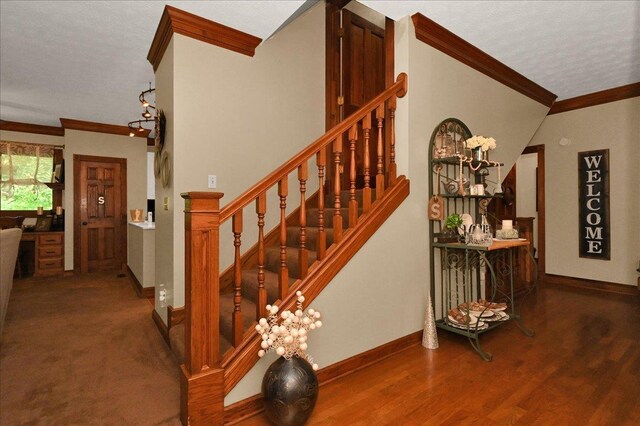  - stairs featuring crown molding, baseboards, wood finished floors, and a textured ceiling