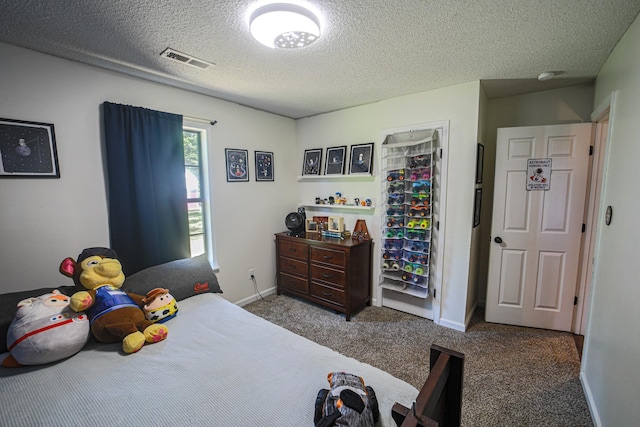  - carpeted bedroom with a textured ceiling and baseboards